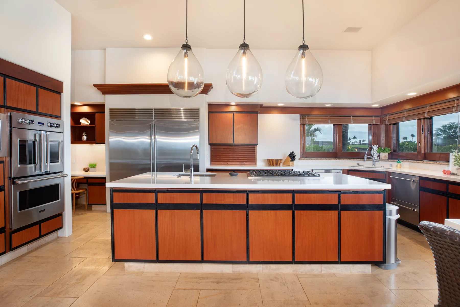 Una cocina amplia con una gran isla central y electrodomésticos de acero inoxidable.