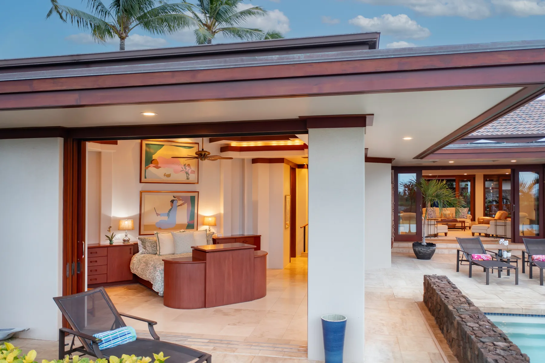 Un dormitorio abierto junto a un patio cubierto y una piscina.