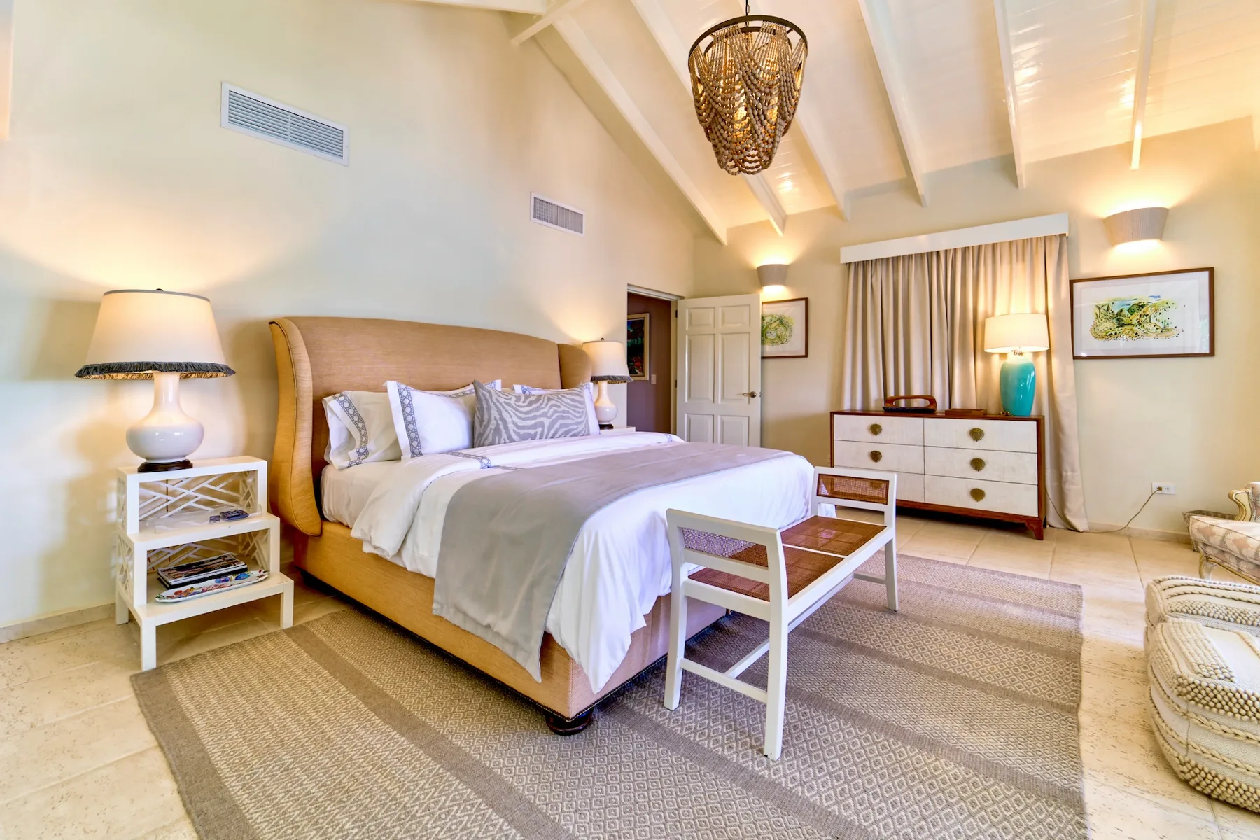 A bedroom with a large bed, bedside table, and dresser.