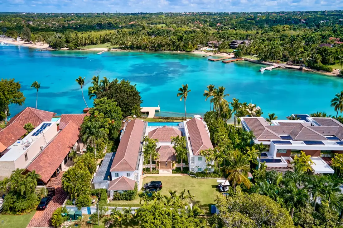 Aerial view of waterfront buildings beside a bright turquoise bay.