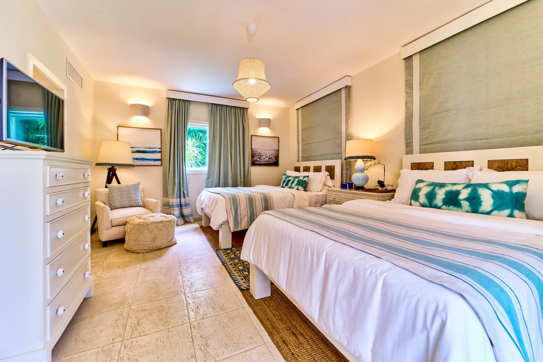 A bedroom with two beds, striped bedding, and a window with curtains.