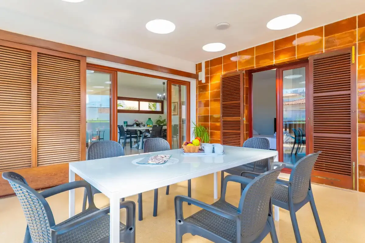 A dining area with a table and chairs beside open sliding doors.