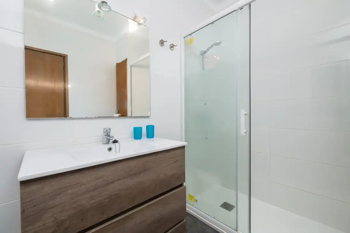 A bright bathroom with a wide vanity and glass shower.