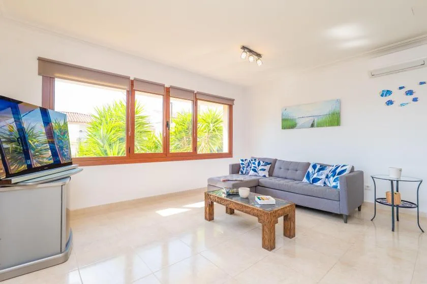 A bright living room with a gray seating area and a wooden coffee table.