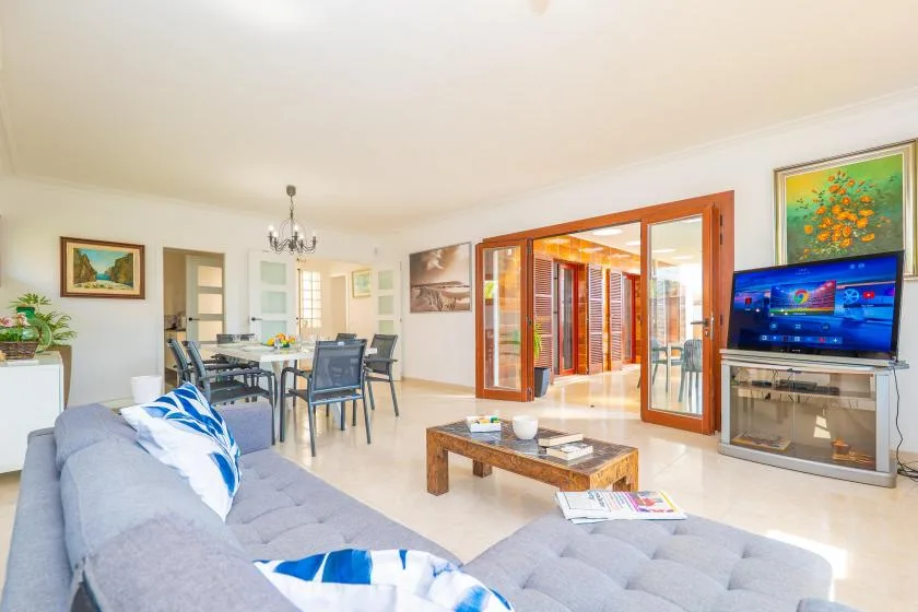 A bright living and dining area with seating, a dining table, and sliding glass doors.