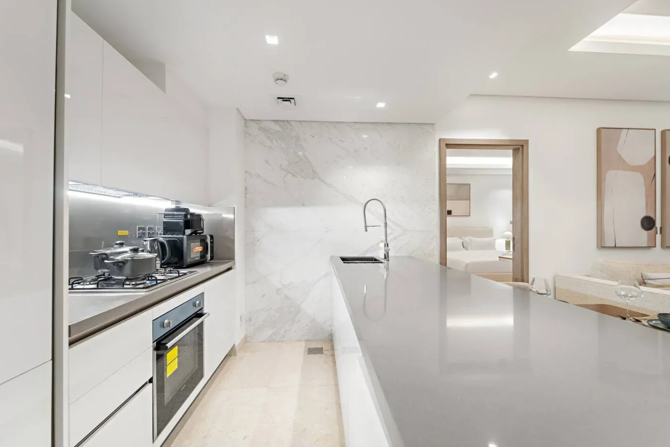 Una cocina moderna y luminosa con una isla larga y electrodomésticos integrados.
