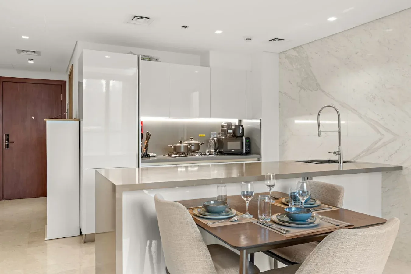 Una cocina moderna y zona de comedor con una encimera y una mesa puesta para comer.