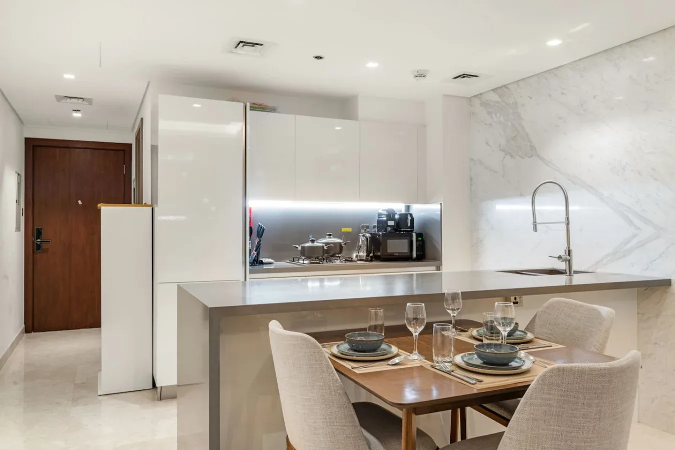 Una cocina moderna y zona de comedor con una mesa junto a la encimera.