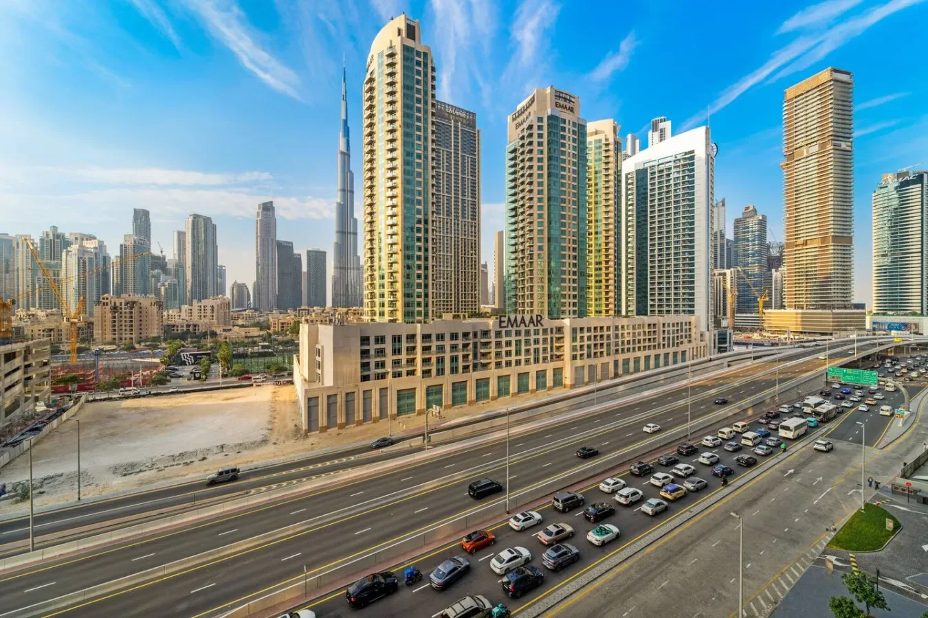 Un horizonte urbano de edificios altos domina una autopista concurrida de varios carriles.