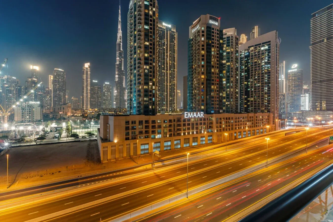 Un horizonte urbano nocturno se alza sobre carreteras muy iluminadas.