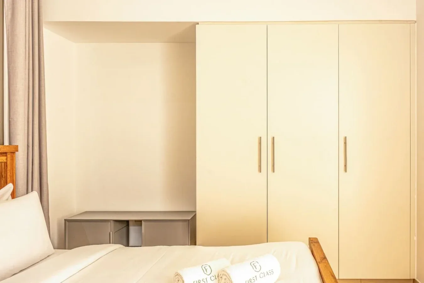 A bedroom with a bed, a built-in wardrobe, and a small desk.