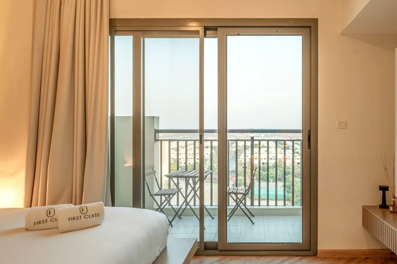 A bedroom with a bed facing glass doors that open onto a balcony.