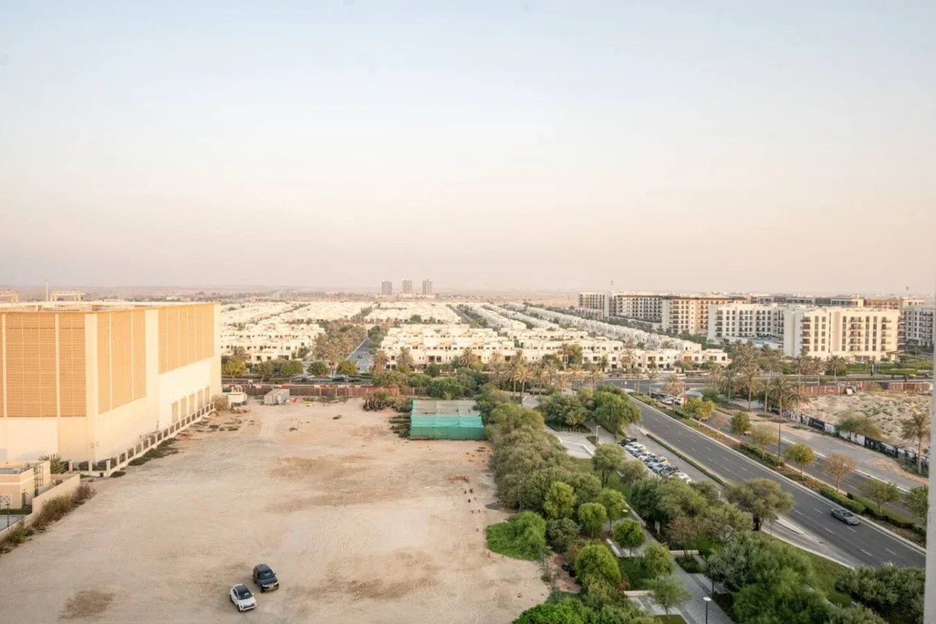 Aerial view of a broad urban area with roads, buildings, and trees.