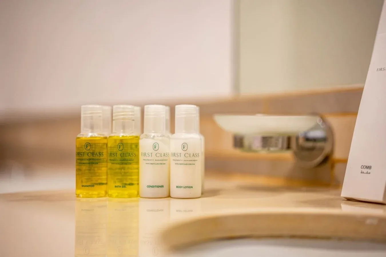 Toiletries sit on a bathroom counter beside a wall-mounted fixture.