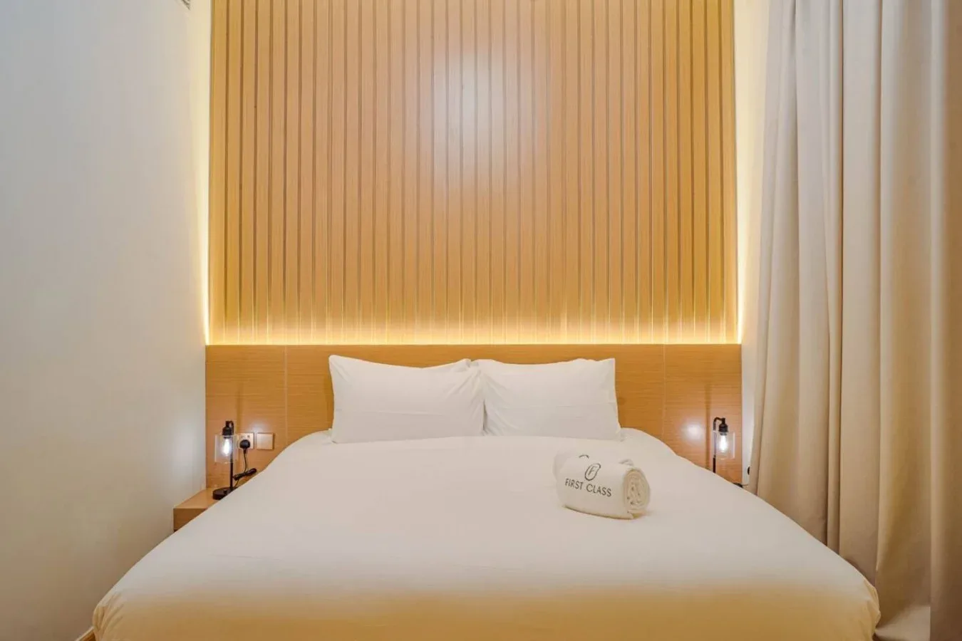 A bedroom with a neatly made bed against a warm, vertically paneled wall.