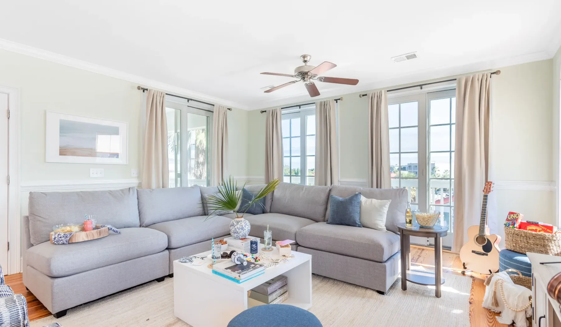 Una sala luminosa con asientos en forma de L y ventanas grandes.