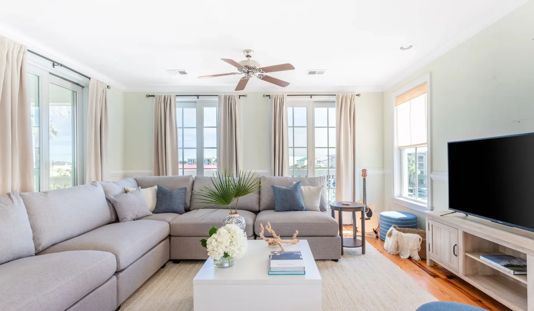 A bright living room with a sectional seating area and large windows.