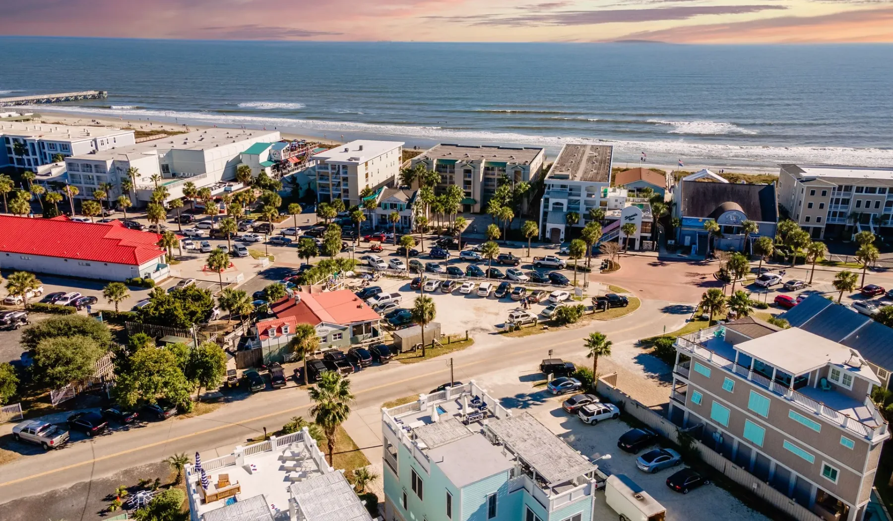 Coastal neighborhood with buildings and a road beside the ocean.