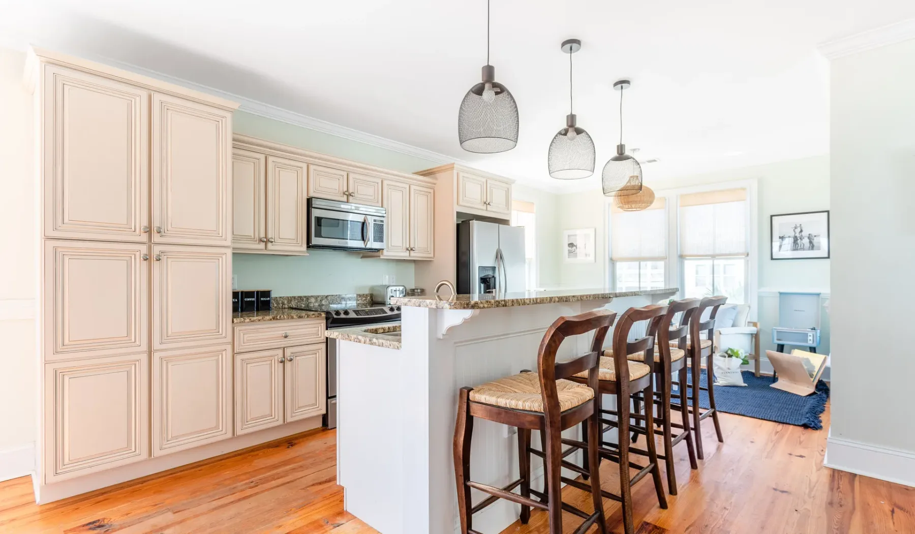 A bright kitchen with a long island and wooden bar seating.