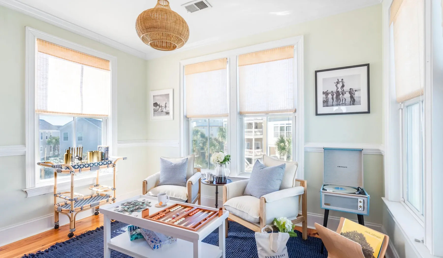 A bright living room with seating, a coffee table, and large windows.