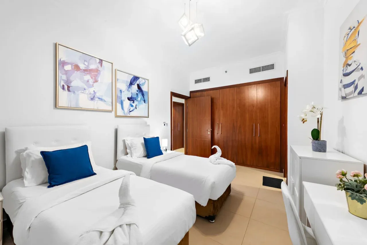 Un dormitorio con dos camas bien hechas y armarios de madera.