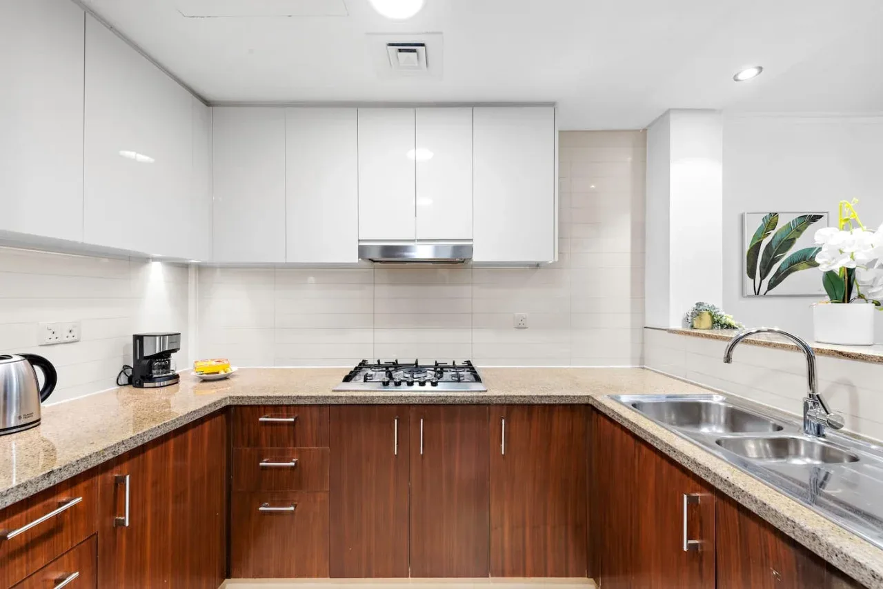 Una cocina luminosa con gabinetes de madera, una estufa y un fregadero.