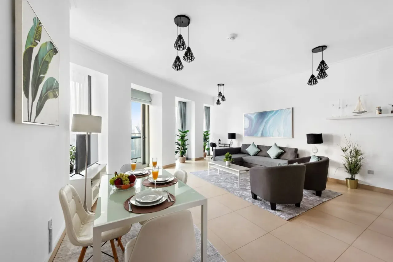 Un salón-comedor luminoso con una mesa junto a una zona de estar.