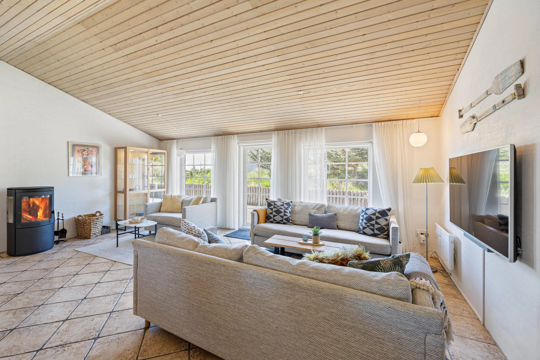 Una sala luminosa con asientos alrededor de una mesa de centro y un televisor.