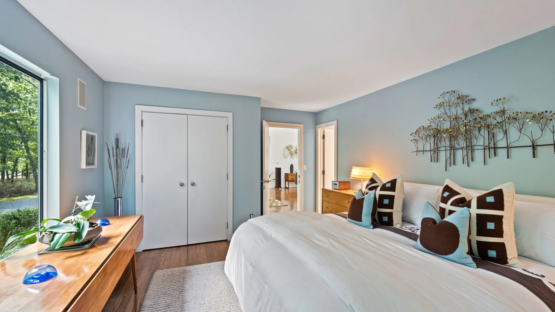 Un dormitorio con una cama bien hecha y paredes azules.