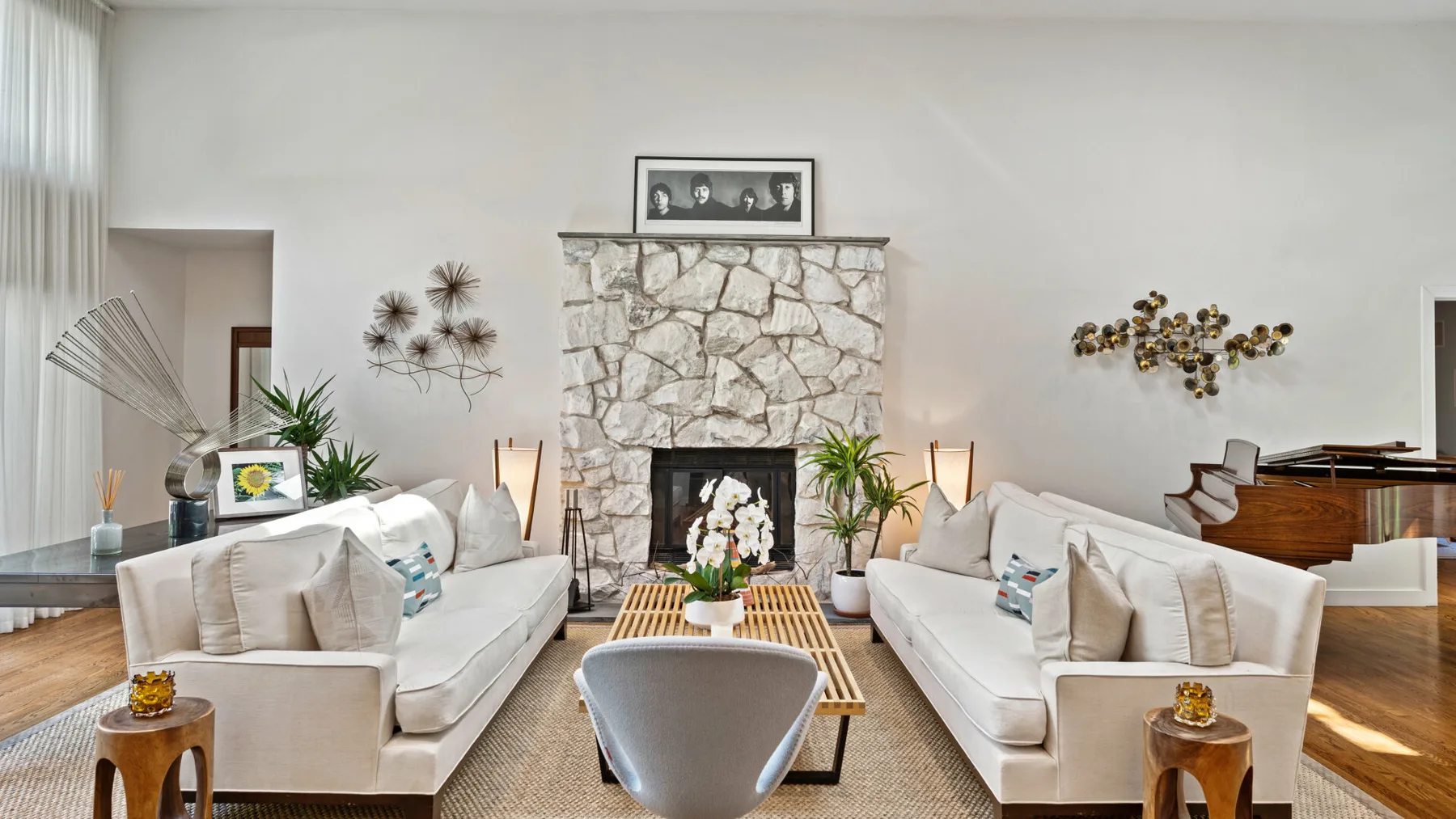 Una sala luminosa con asientos enfrentados, una chimenea de piedra y una mesa de centro.