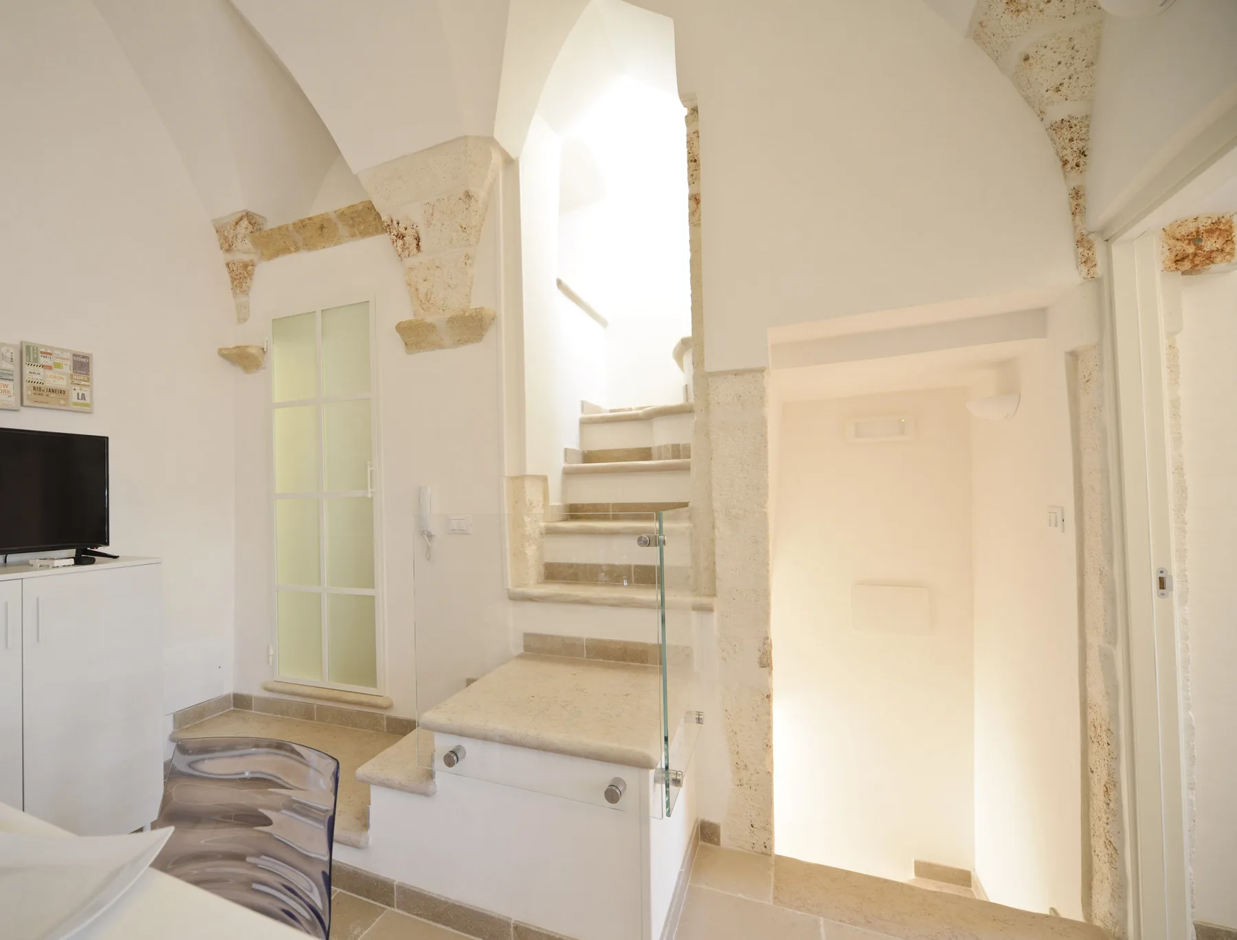 Una habitación luminosa con una zona elevada para dormir y una barandilla de vidrio.