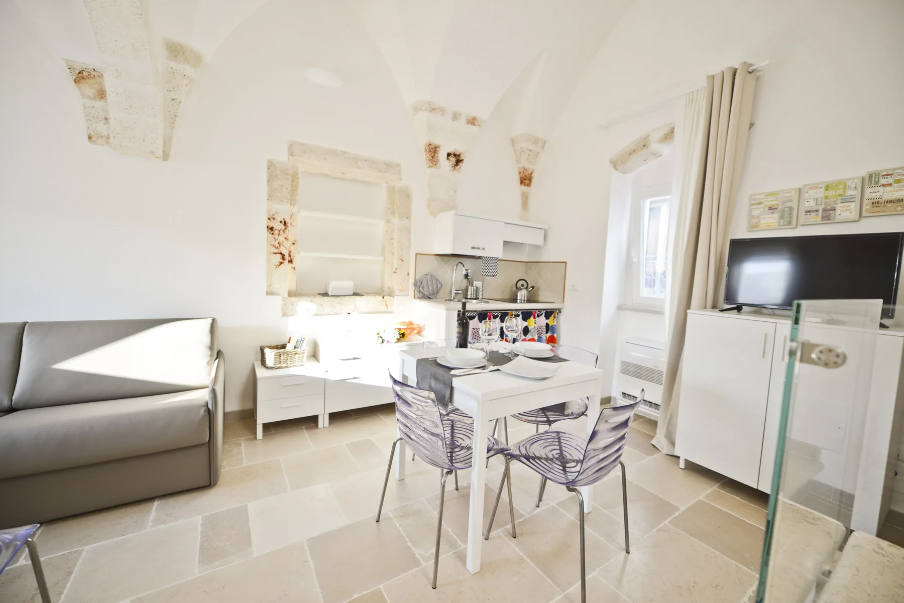 Una luminosa sala de estar con mesa de comedor y cocina pequeña.
