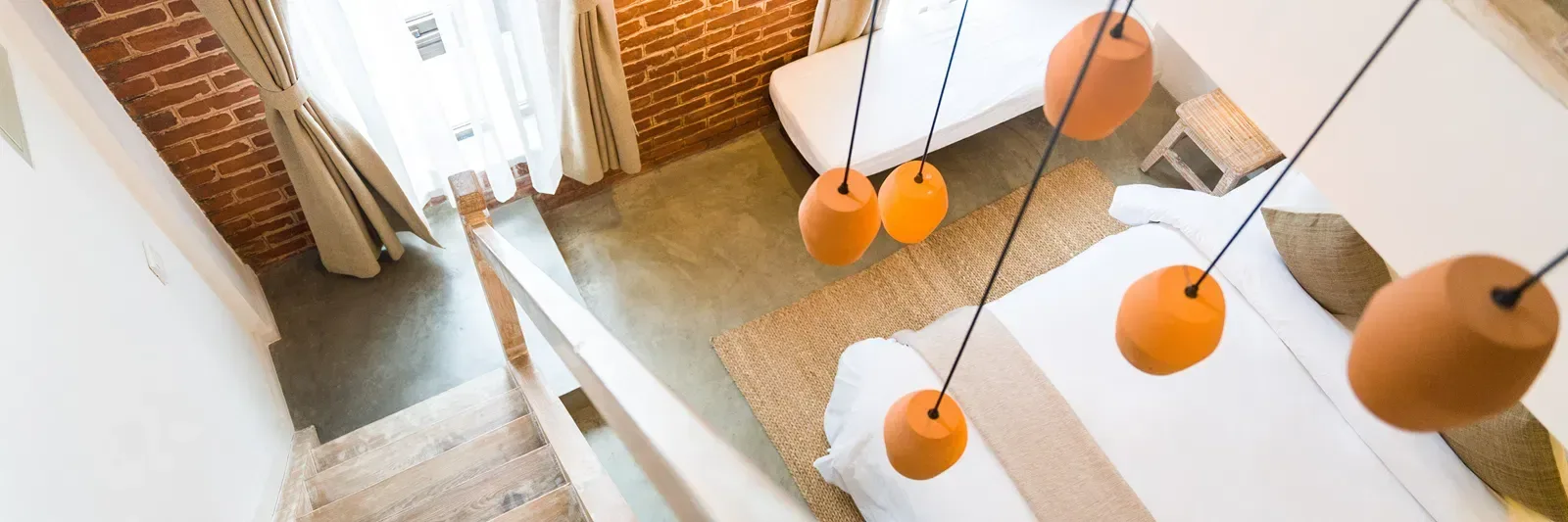 Aerial view of a loft room with staircase and chandelier.