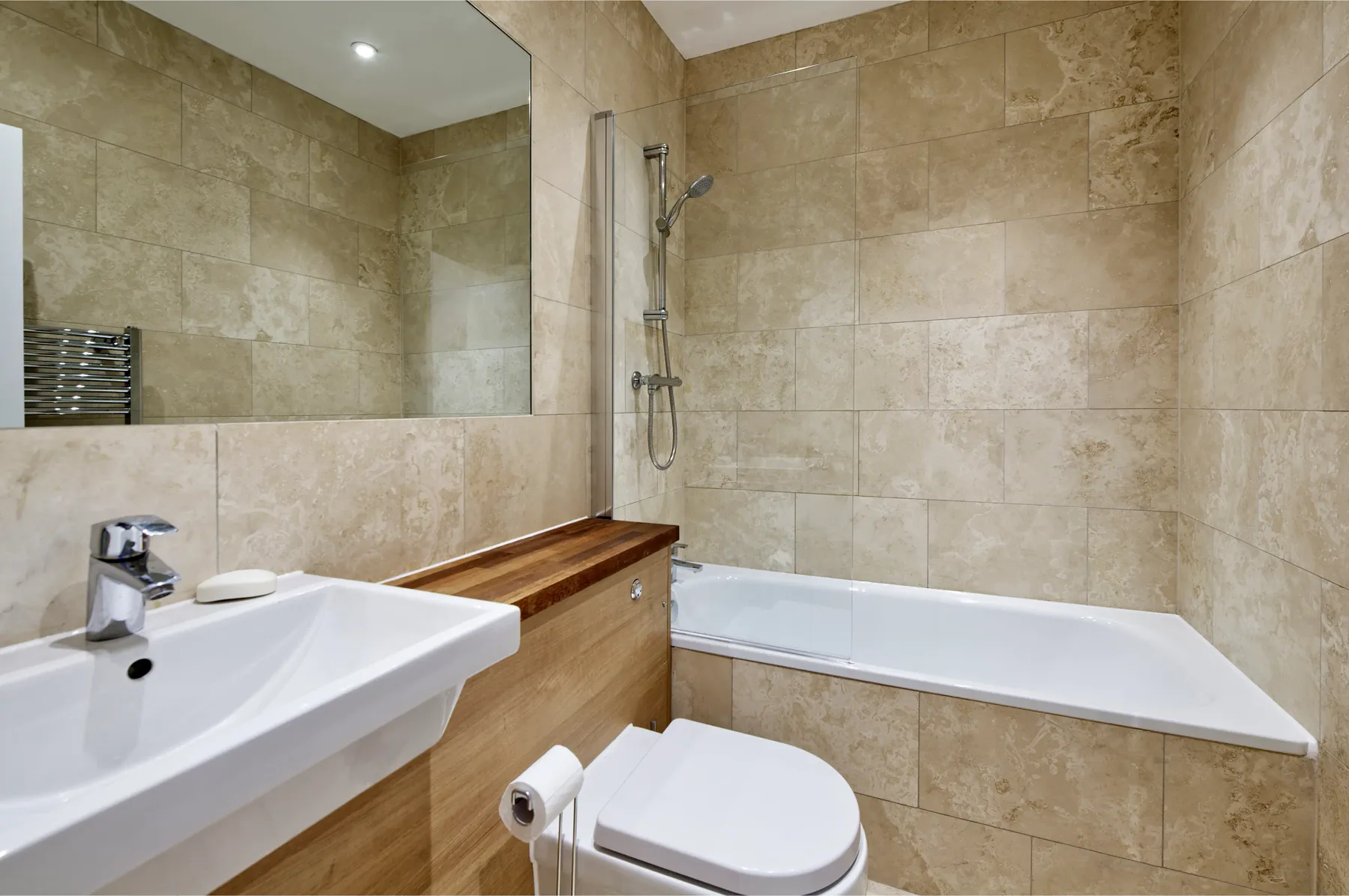 A tiled bathroom with a bathtub, shower, sink, and toilet.