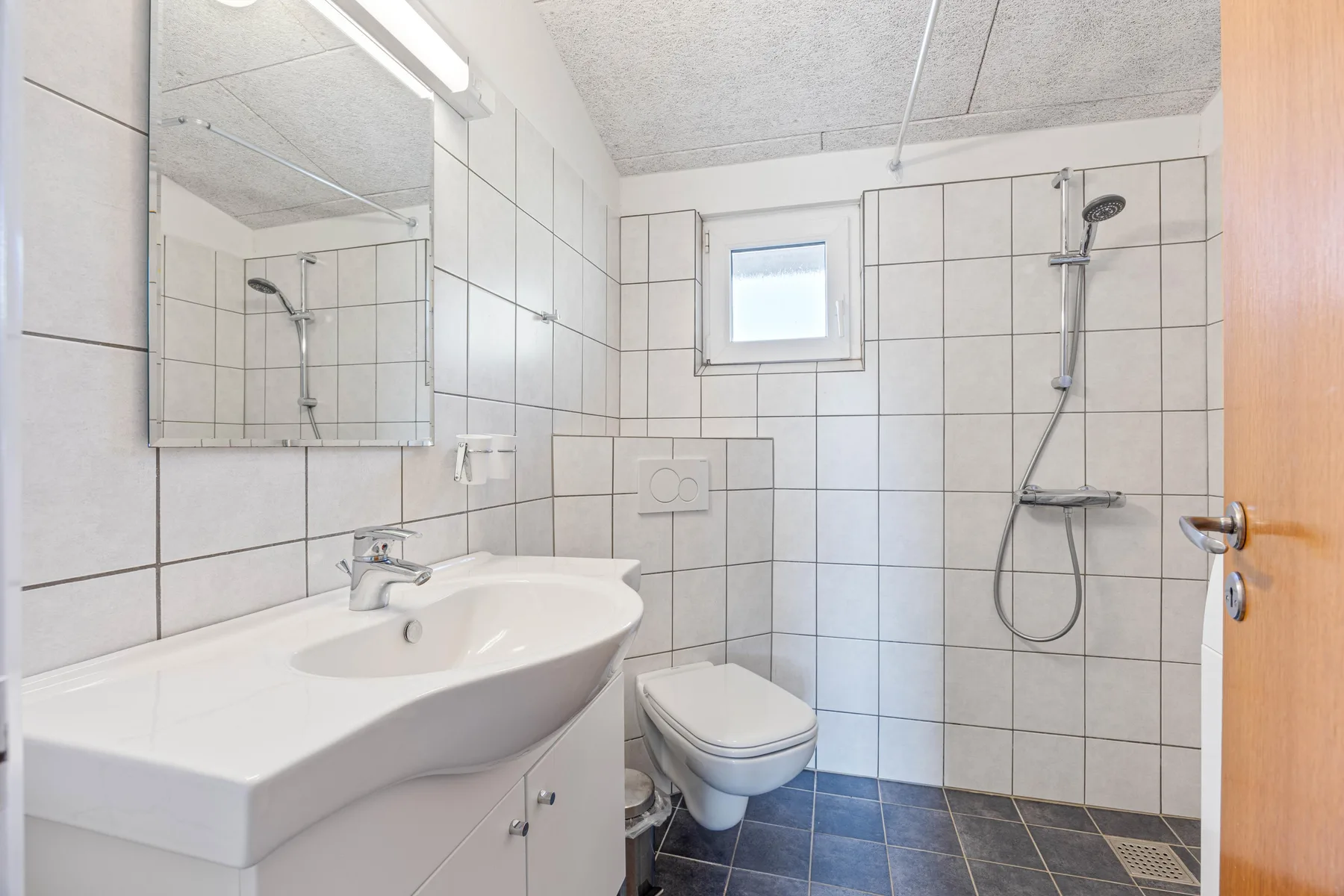 Un baño alicatado con lavabo, inodoro y ducha.