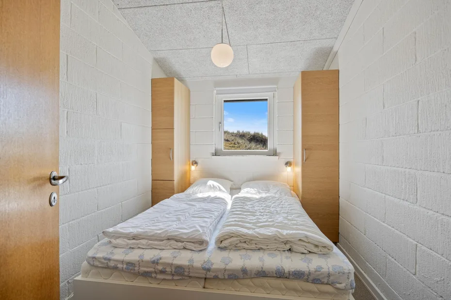 Un dormitorio con dos camas frente a una ventana.