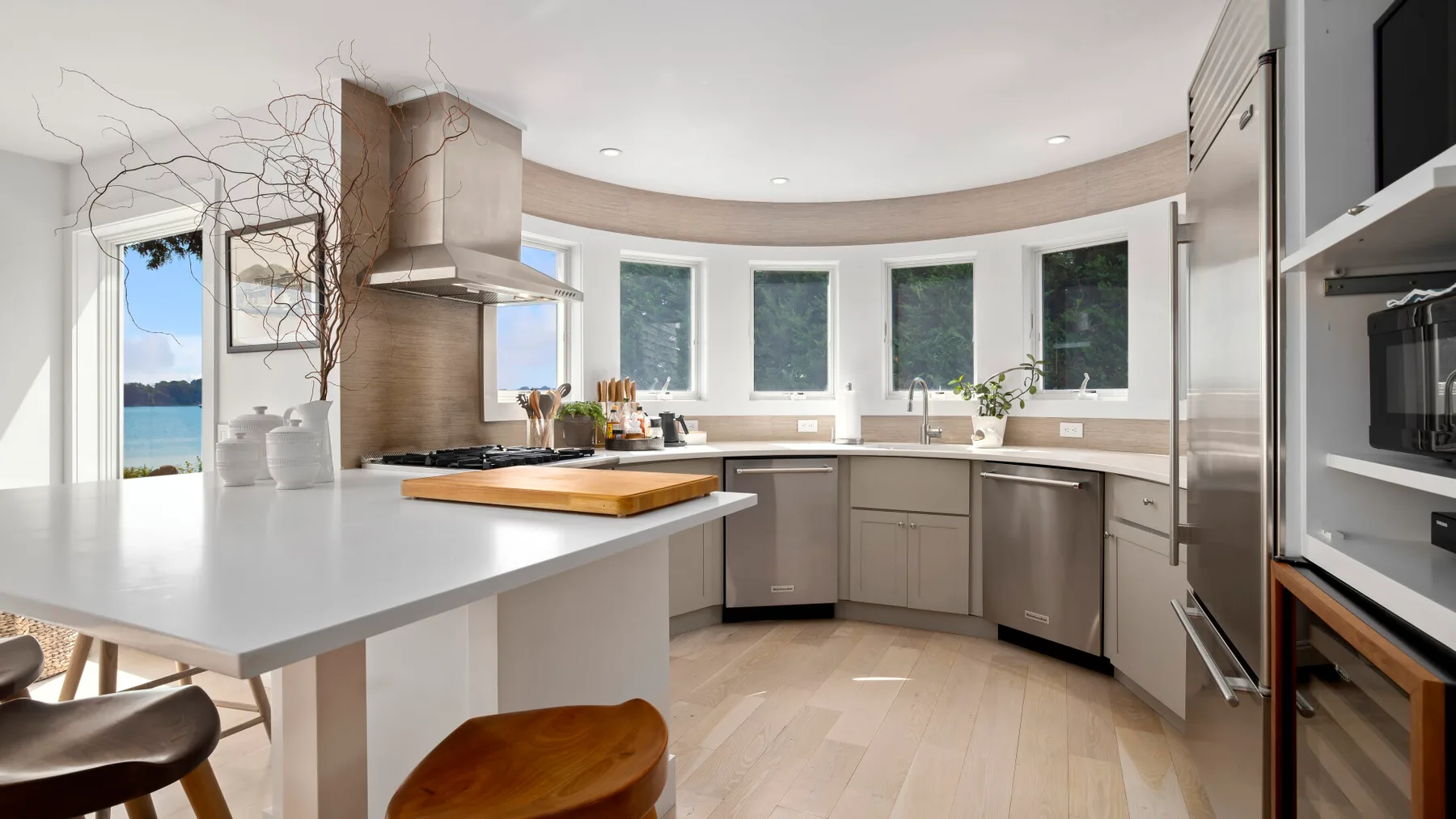 A bright kitchen with a curved row of windows and a central island.