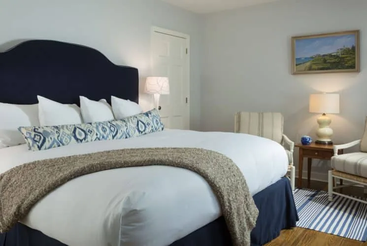 Dormitorio Primrose con cabecera tapizada en azul marino y zona de estar