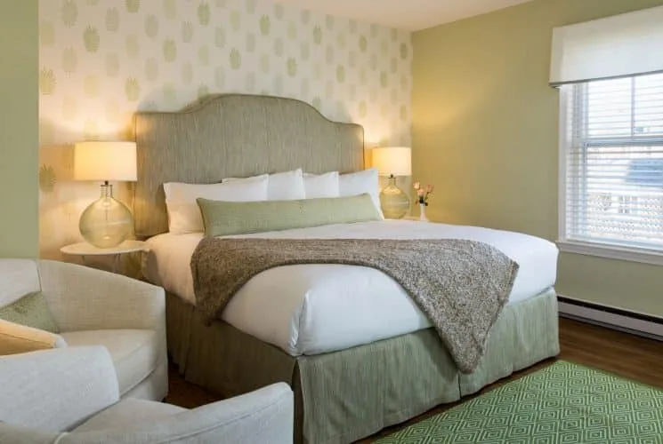 Dormitorio Hydrangea con papel tapiz estampado y cabecera tapizada en verde