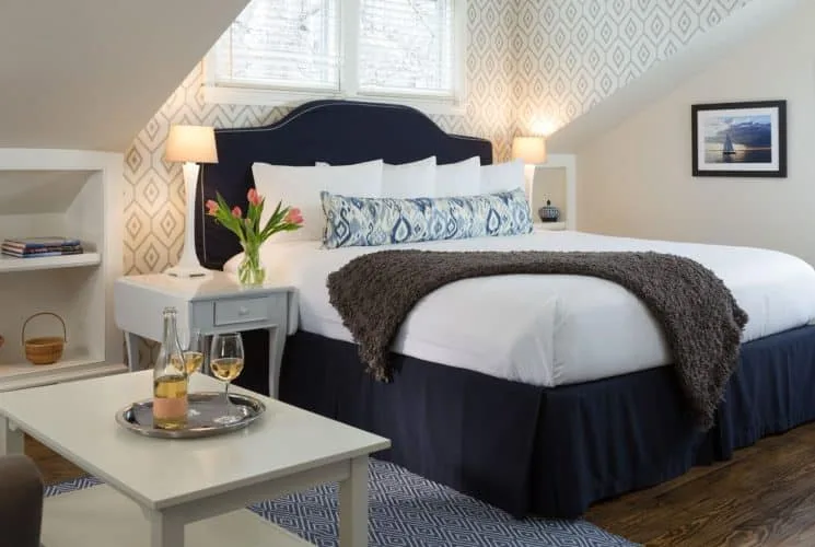 Dormitorio Wisteria con cabecera tapizada en azul marino y zona de estar