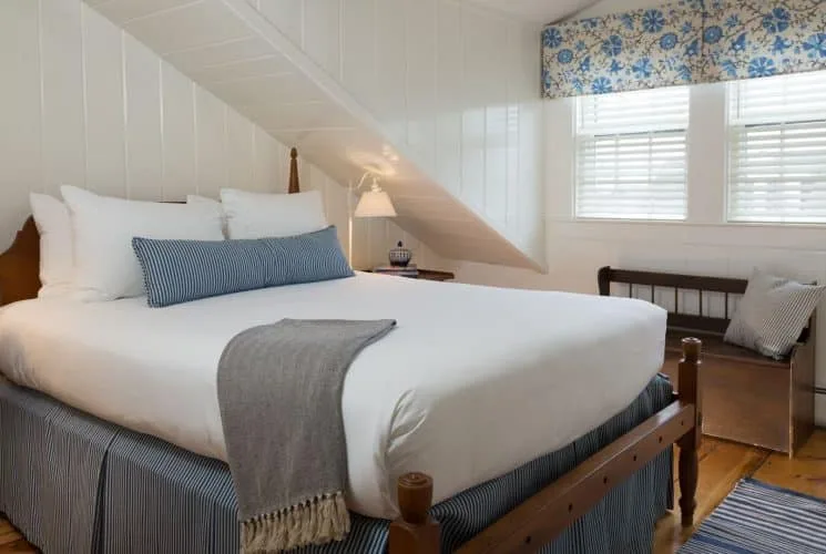 Dormitorio de la Atlantic Suite con cama de madera oscura y ropa de cama blanca