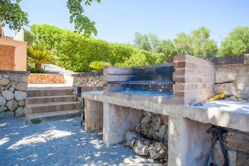 Una zona de barbacoa al aire libre con encimeras integradas y escalones al lado.