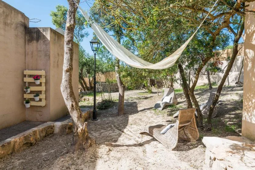 Una zona de descanso al aire libre con una hamaca colgada entre los árboles.