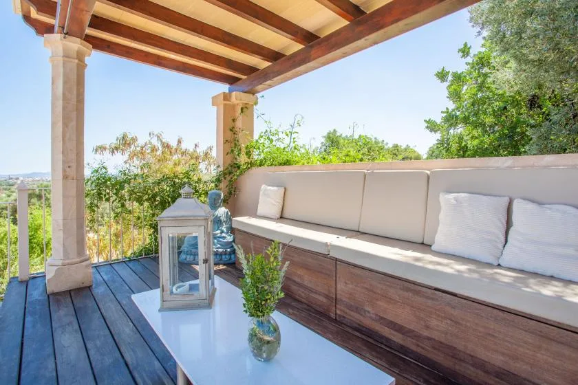 Una zona exterior cubierta cuenta con un banco y una mesa baja.