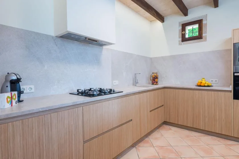 Una cocina luminosa con armarios de madera, una placa de cocción y una ventana pequeña.
