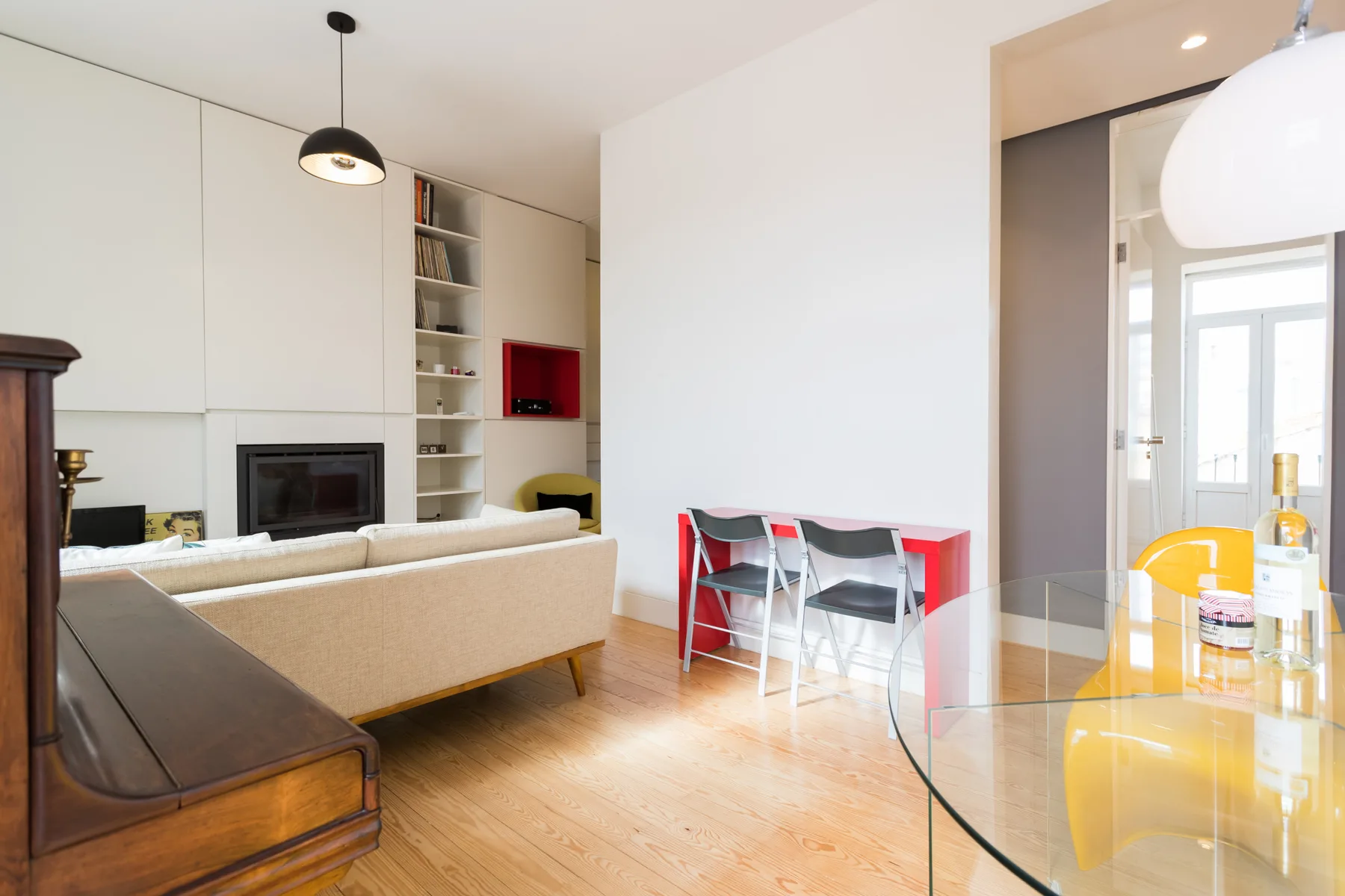 Una sala de estar luminosa con sofá, televisor y mesa de comedor.