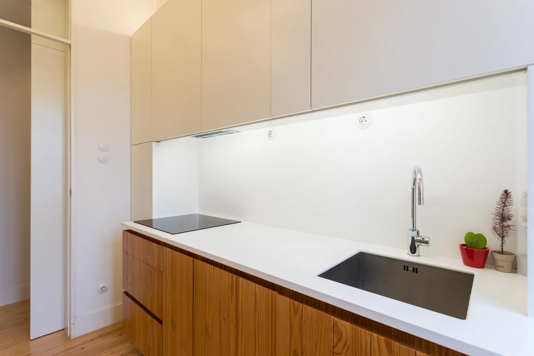 Una cocina moderna con encimera, fregadero y armarios superiores.