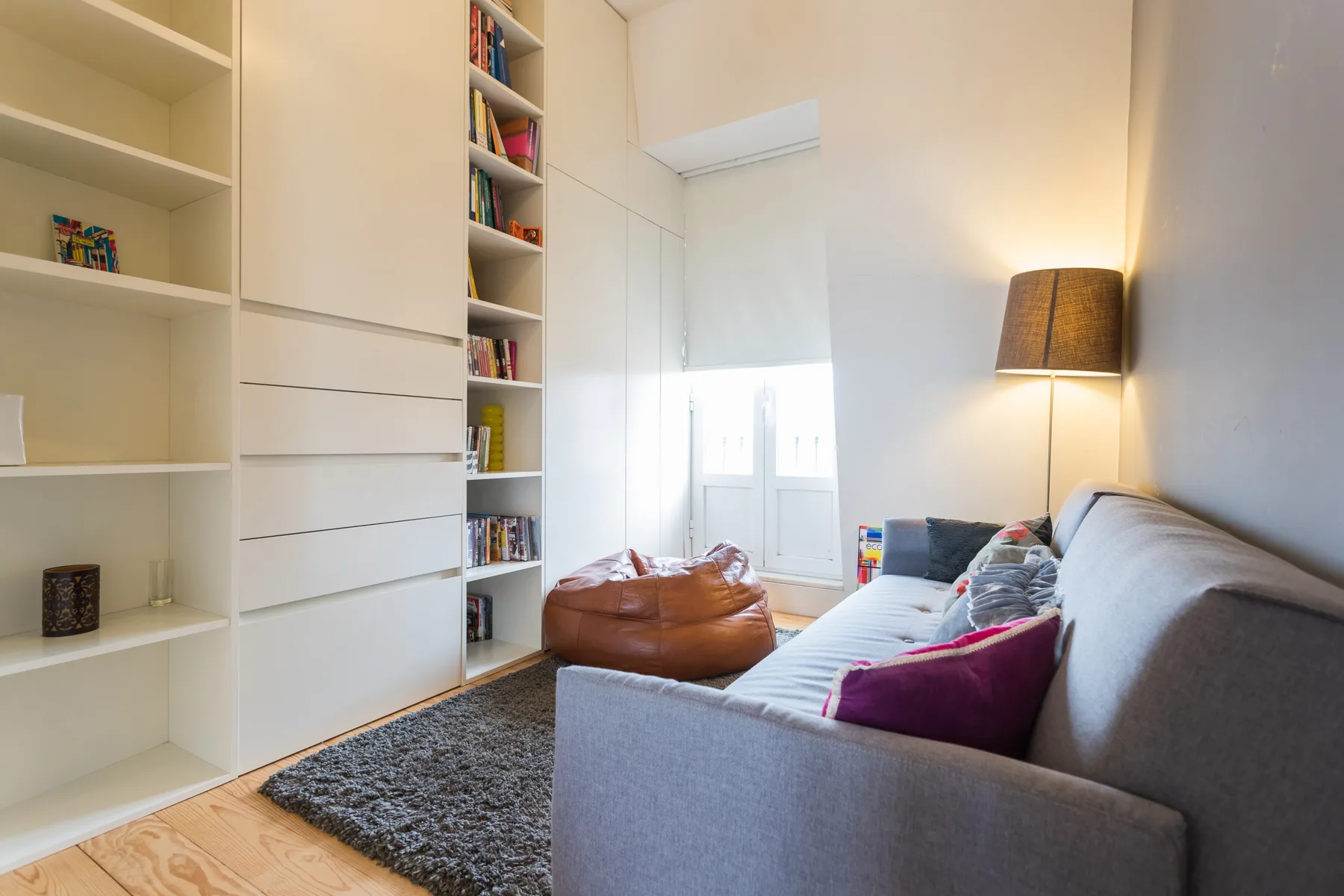 Sala de estar con asientos, estanterías empotradas y una ventana luminosa.