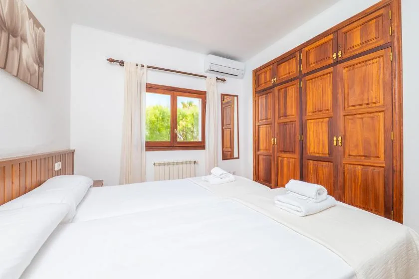Un dormitorio luminoso con una cama grande y armarios empotrados de madera.