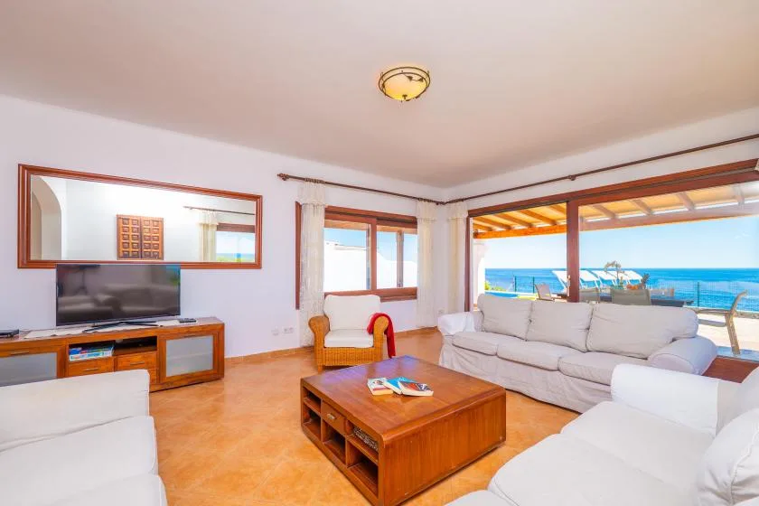 Una luminosa sala de estar se abre a una terraza con vista al mar.